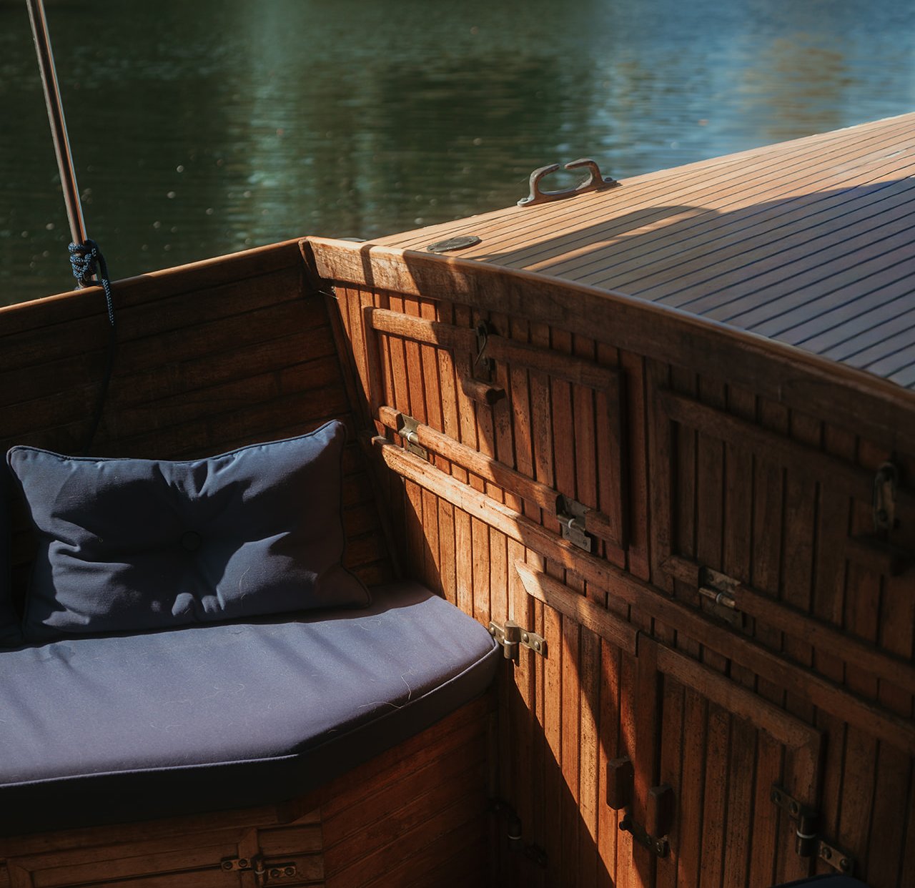 A cushioned seat in the teak-panelled bow, overlooking the river