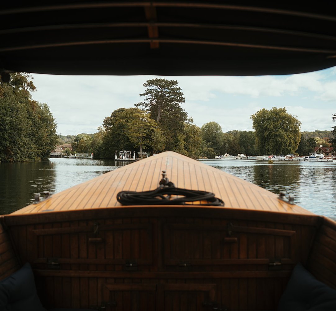 View over the bow from beneath the canopy while cruising the River Thames