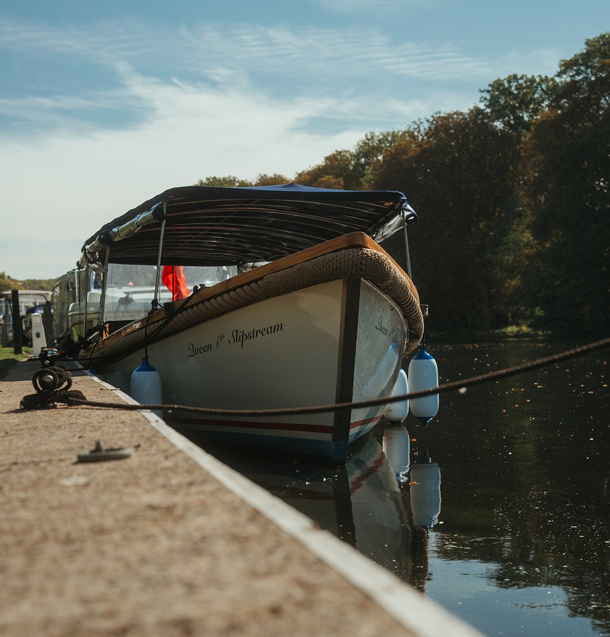 Queen of the Slipstream moored alongside the quay under a blue sky